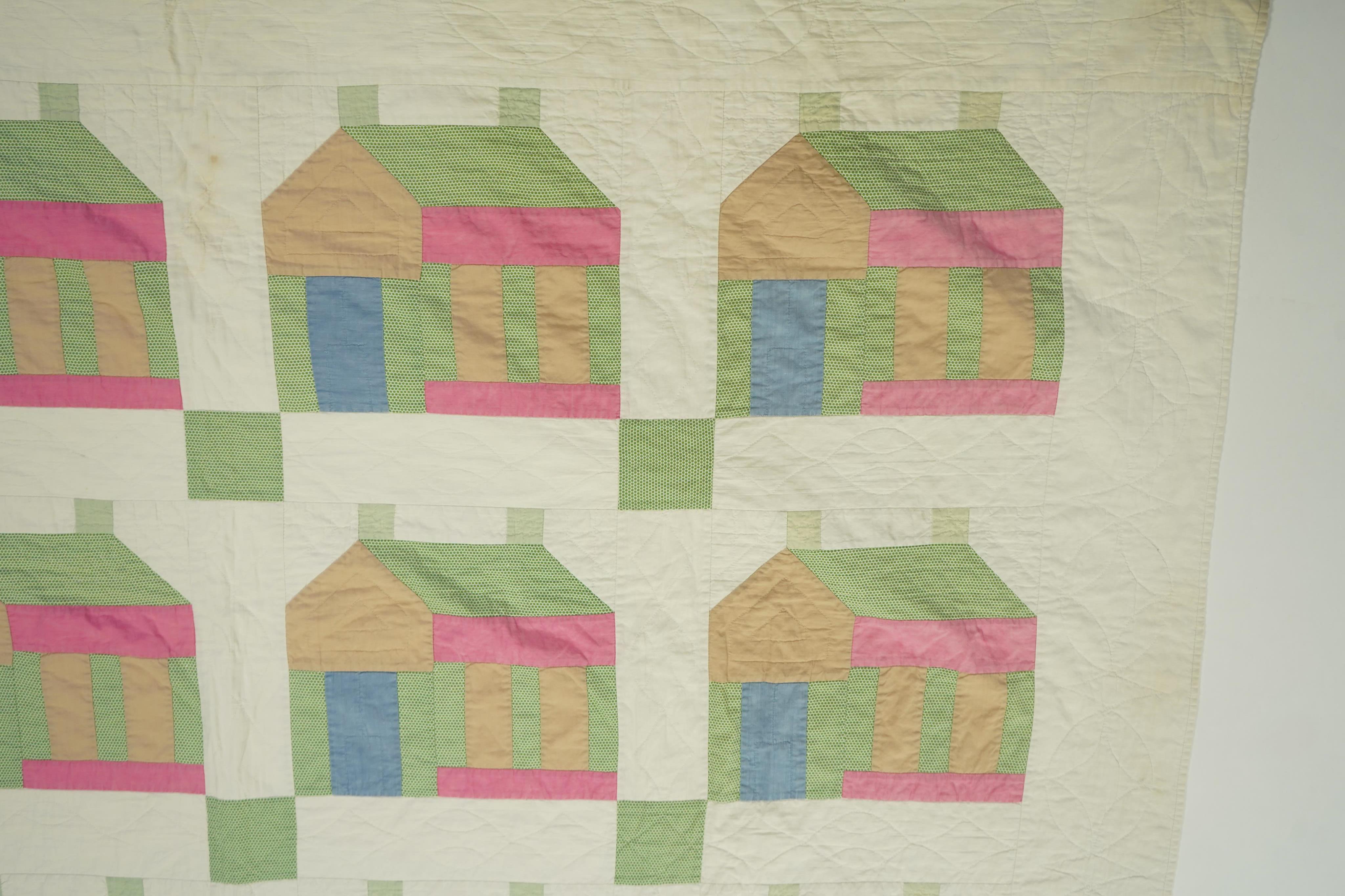 A 1930’s American quilt from Vermont. Quilted in large patchwork ‘house’ motifs, repeating the same four colours in each motif against a plain white background. The reverse a plain white quilted cotton . The quilt hand p